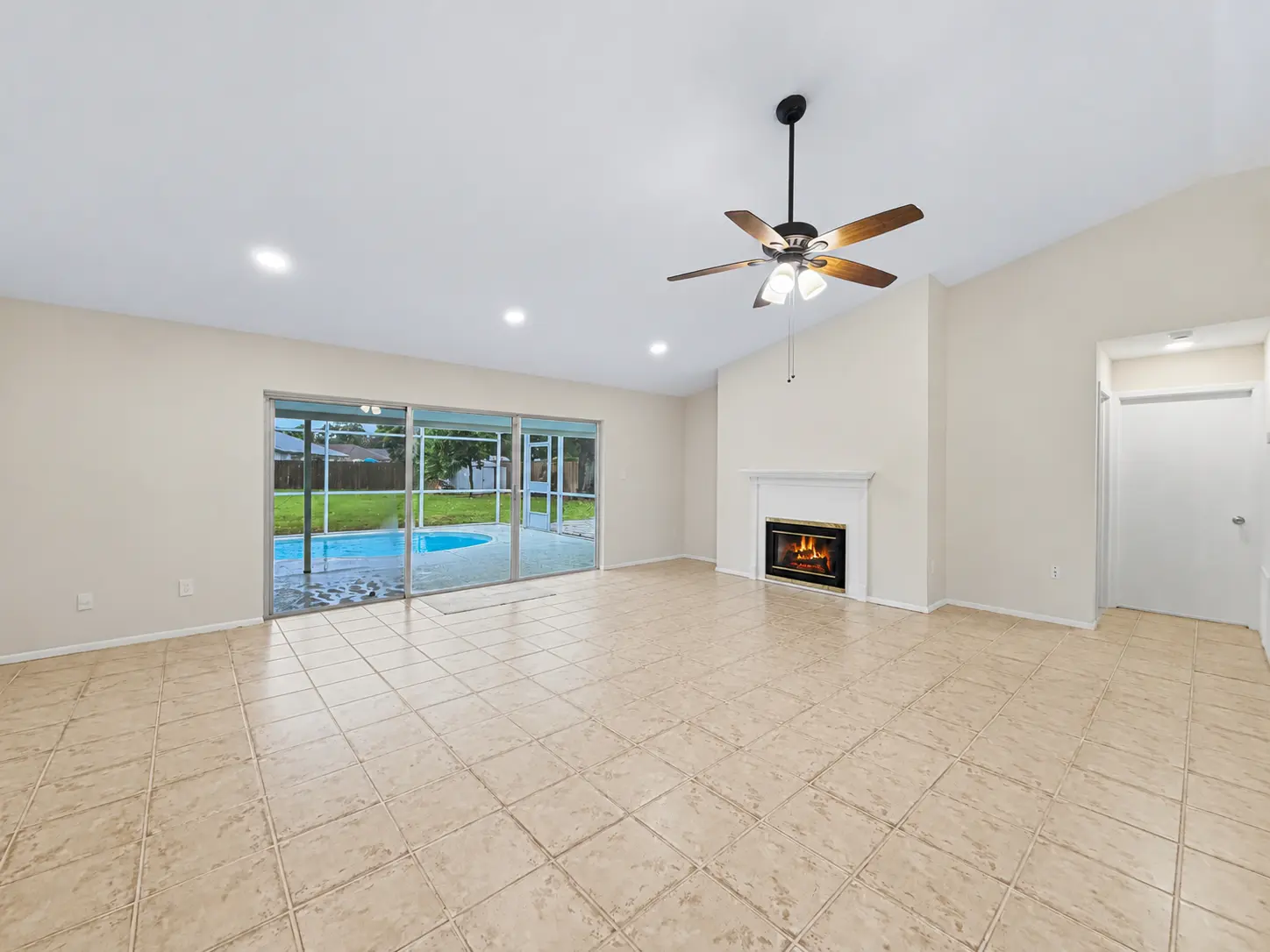 Living room with fireplace and sliding doors to the pool